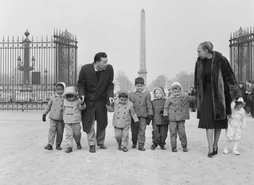 Josephine Baker and her husband Jo Bouillon stroll through the Tuileries in Paris with seven of their adopted children.