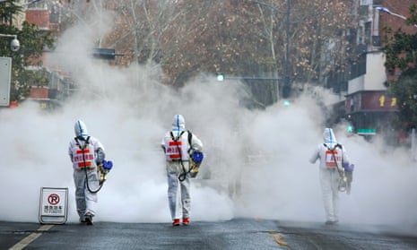 Volunteers wearing PPE spray disinfectant in Zhengzhou, China.