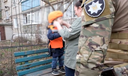 A woman adjusts a helmet in Avdiivka. 