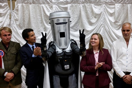Count Binface makes the peace sign with his fingers, alongside the other candidates