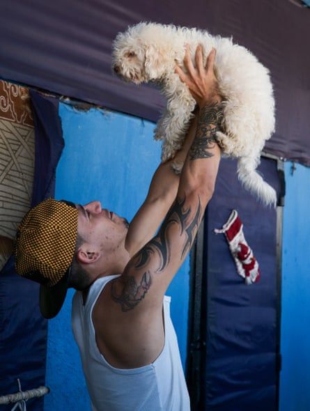 Javier Almeida, a prisoner serving a 15-year sentence on drug charges, plays with his dog outside his cell. He says this dog is like a son to him. Tocuyito, Valencia 2022