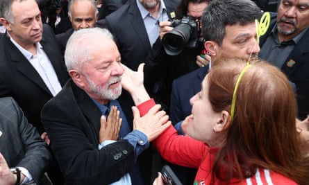 Lula, São Paulo'daki bir sandıkta oyunu kullandıktan sonra bir destekçisini selamlıyor.