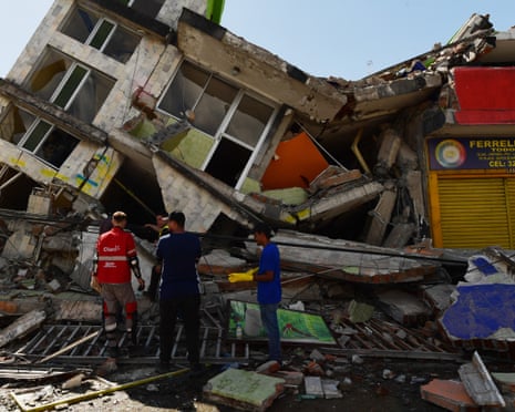 People look for survivors amid the rubble of a collapsed building after an earthquake in Pereira, Colombia.
