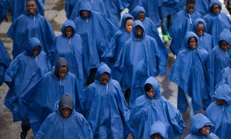 Tourists wear rain ponchos in London on Sunday. The UK forecast suggests further cool and unsettled weather in the coming days.