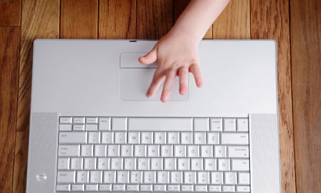 Small child’s hand on a laptop computer keyboard.