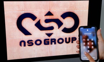 The NSO Group logo on a wall, beside a smartphone