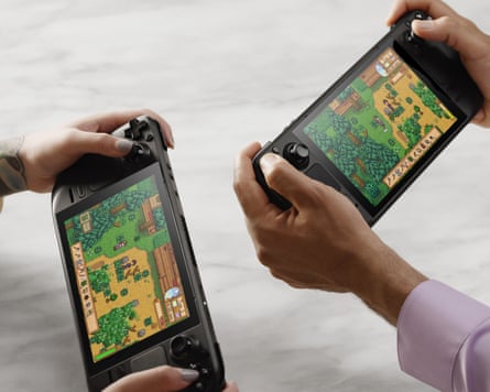 Two sets of hands hold two Steam Deck games consoles