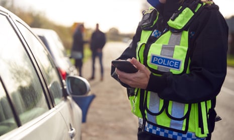 A police officer looking into a car