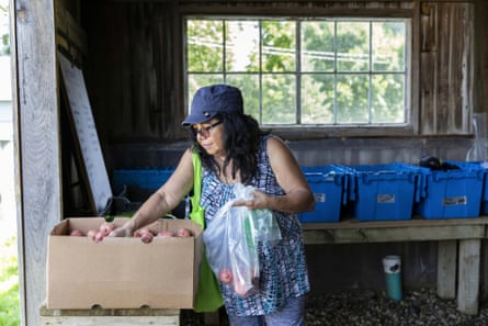 A woman bags produce.