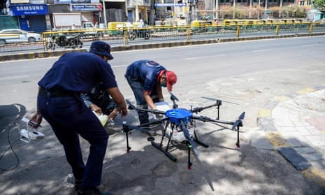Ahmedabad fire and emergency services personnel fill a drone with disinfectant to be sprayed on streets