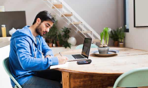 ▼ A number of institutions, such as the University of Surrey, offer discounts for returning alumni photograph: getty images Young man working on his laptop at home.