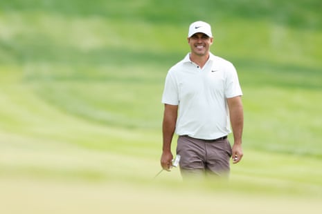 Brooks Koepka of the United States smiles as he walks up the fourth hole.