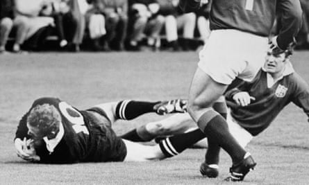 Wayne Cottrell (left) of the All Blacks dives past Mike Gibson to score the Kiwis’ first try in the fourth Test in Auckland.