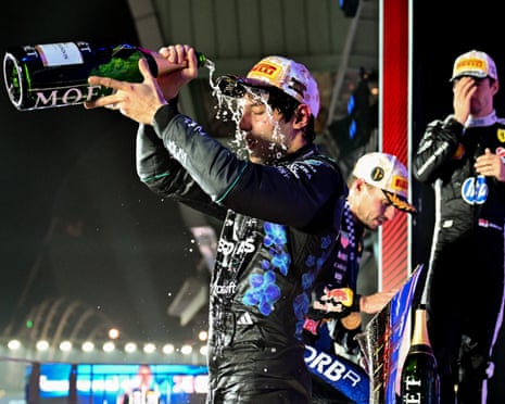 Kimi Antonelli pours champagne over his head on the podium after the Singapore GP