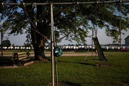 Metal gas storage tanks surround a green park and trees.