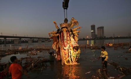 A giant idol of Hindu goddess Durga is immersed in the Yamuna river.