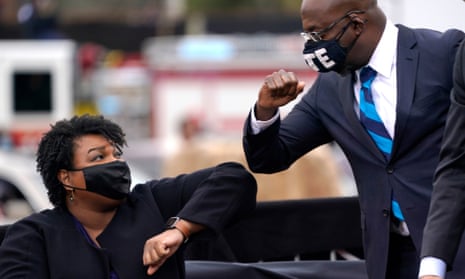 Stacey Abrams and Raphael Warnock bump elbows during a rally in Atlanta last month.