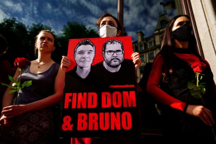 Supporters hold roses and a sign reading ‘Find Dom & Bruno’.