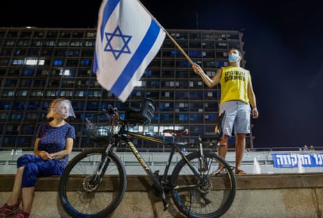 Israeli protesters, wearing protective gear due to the coronavirus pandemic, take part in a demonstration against prime minister Benjamin Netanyahu in the coastal city of Tel Aviv.