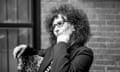 Black and white portrait of Lynne Tillman, sitting in a chair and looking to the left.