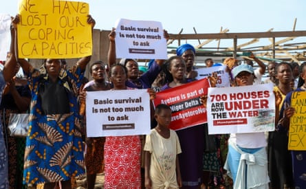 People hold up signs with slogans such as ‘Basic survival is not too much to ask. #SaveAyetoro’ and ‘700 houses are now under the water’.