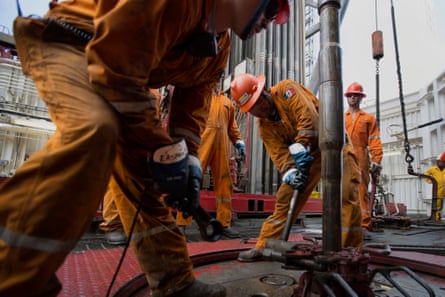 Workers prepare a drilling pipe on a deepsea crude oil platform in the waters off Veracruz, Mexico.