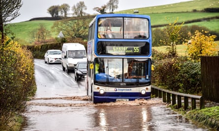 A bus drives through flood water on the main A396 between Tiverton and Exeter, near Upexe