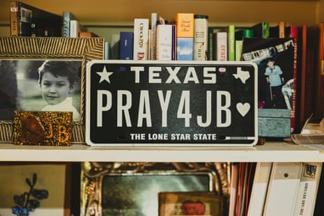 A Texas license plate on a bookshelf with family photos