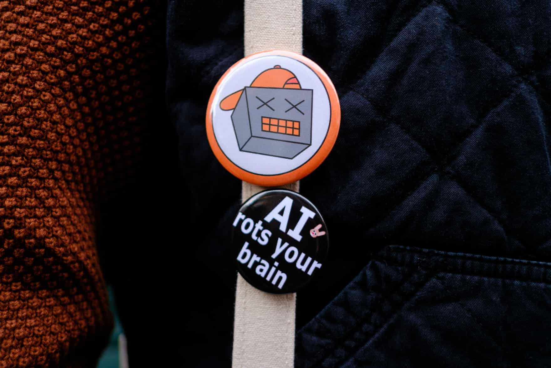 a button on a bag reads ‘AI rots your brain’