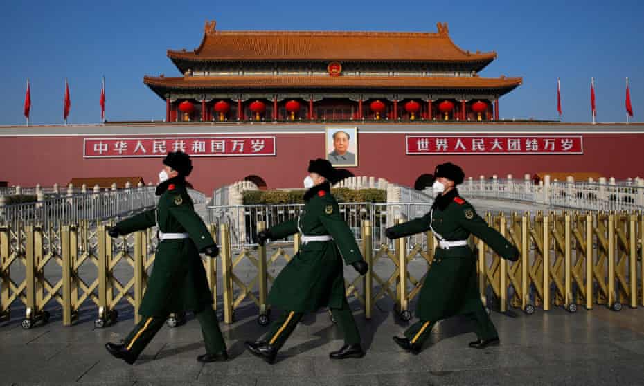 Chinese paramilitary police officers wear masks as they patrol at Tiananmen Square in Beijing, China