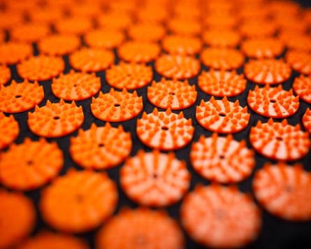 A closeup of orange discs with spikes on a black mat