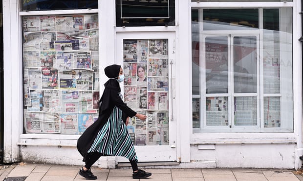 A woman walks past an empty, closed down shop in Newcastle-Under-Lyme, England.