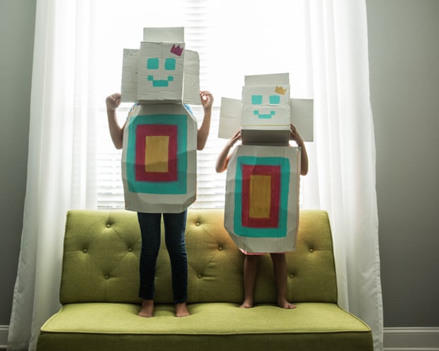 Young girls wearing homemade robot costumes at home