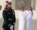 Saudi ceremonial guards stand at attention as officials in white robes await arriving dignitaries