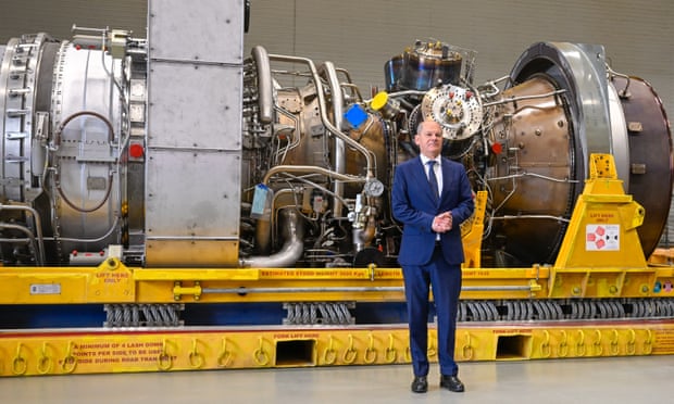 Olaf Scholz stands in front of a turbine of the Nord Stream 1 pipeline.