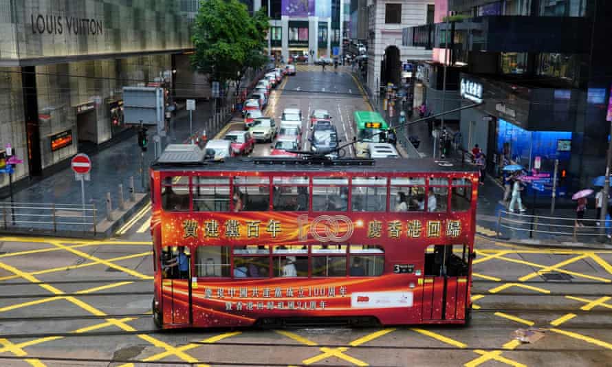 A tram with a slogan celebrating the 100th anniversary of the founding of the Chinese Communist Party and the 24th anniversary of Hong Kong’s return to China drives along the street in Hong Kong