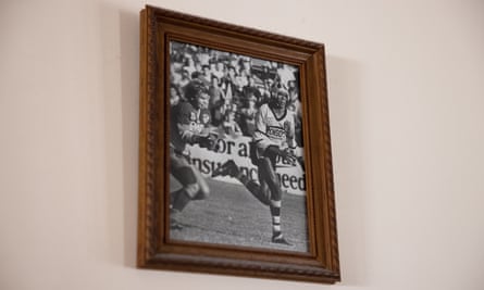 An archival image of Dotti playing rugby league, in a photo on a wall at his home