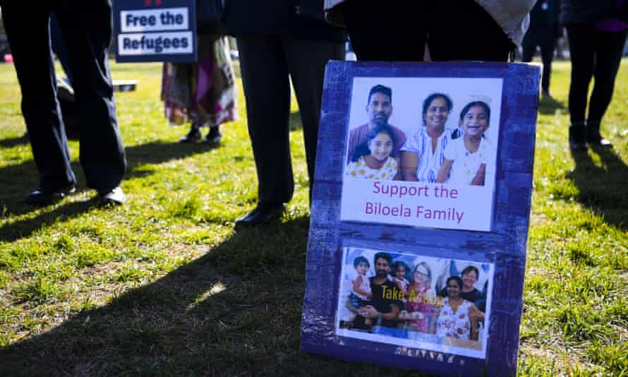 A demonstrator outside Parliament House in Canberra shows a sign in support of the Biloela Tamil family.