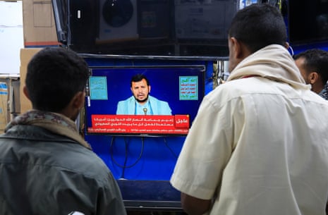 People watch Houthi leader Abdul-Malik al-Houthi delivering a TV speech in Sana’a, Yemen.