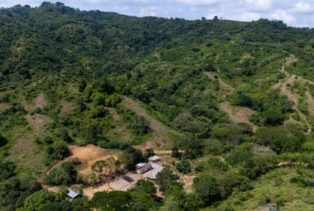 an aerial view of buildings in a clearing in the forest