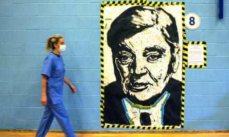 A nurse walks past a portrait of Aneurin Bevan, the architect of the NHS, in Cwmbran, Wales, in October 2021.