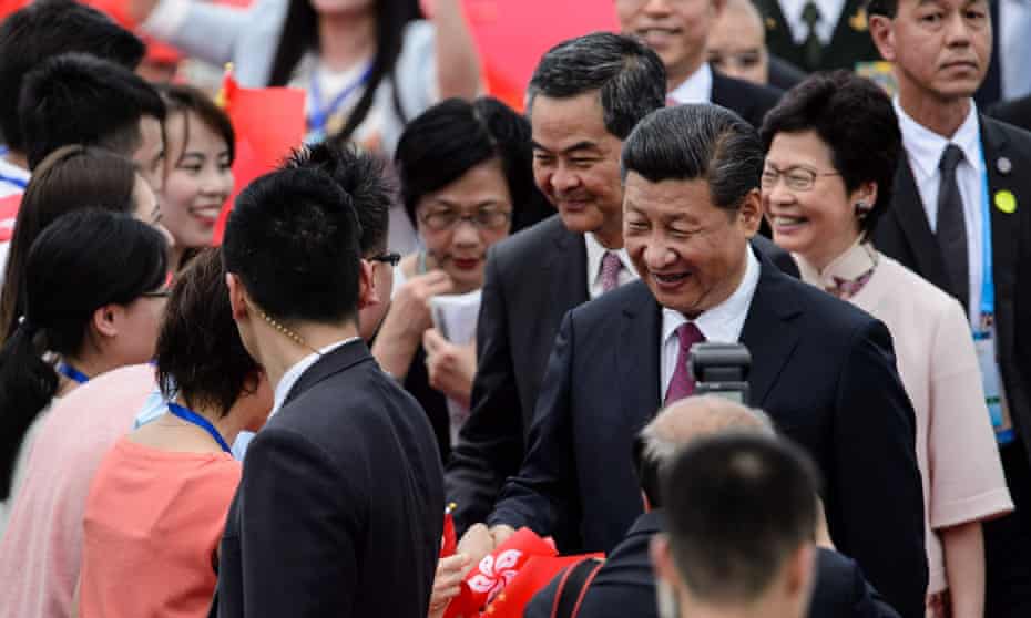 China's President Xi Jinping (2nd R) is greeted by well-wishers upon his arrival at Hong Kong's international airport on June 29