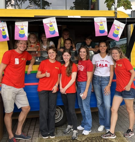 A group of people in red T-shirts standing in front of a food truck.