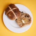 A Morrisons The Best apple & cinnamon hot cross bun, sliced, toasted and buttered, on a white plate