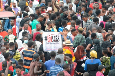 A crowd of protesters, with an #EndSars placard held up in the centre of them.
