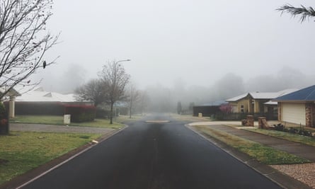 Empty Road Amidst Houses Against Sky During Foggy Weather