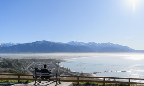 A backpacker looks at the view of Kaikoura and the Kaikoura Ranges in New Zealand