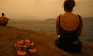Beachgoers peer though bushfire smoke