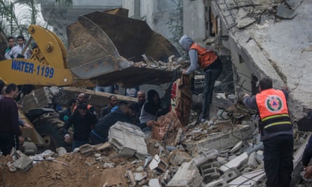 Palestinian civil defence workers search for bodies and survivors after an Israeli airstrike in Deir al-Balah in the southern Gaza Strip.