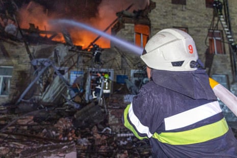 Rescuers work at a site of a building damaged by a Russian drone strike in Kharkiv.